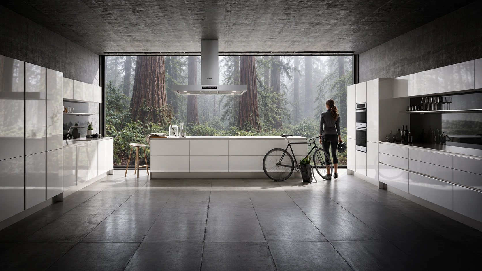 A woman stands beside a bicycle in a modern white Bosch kitchen overlooking a misty redwood forest.