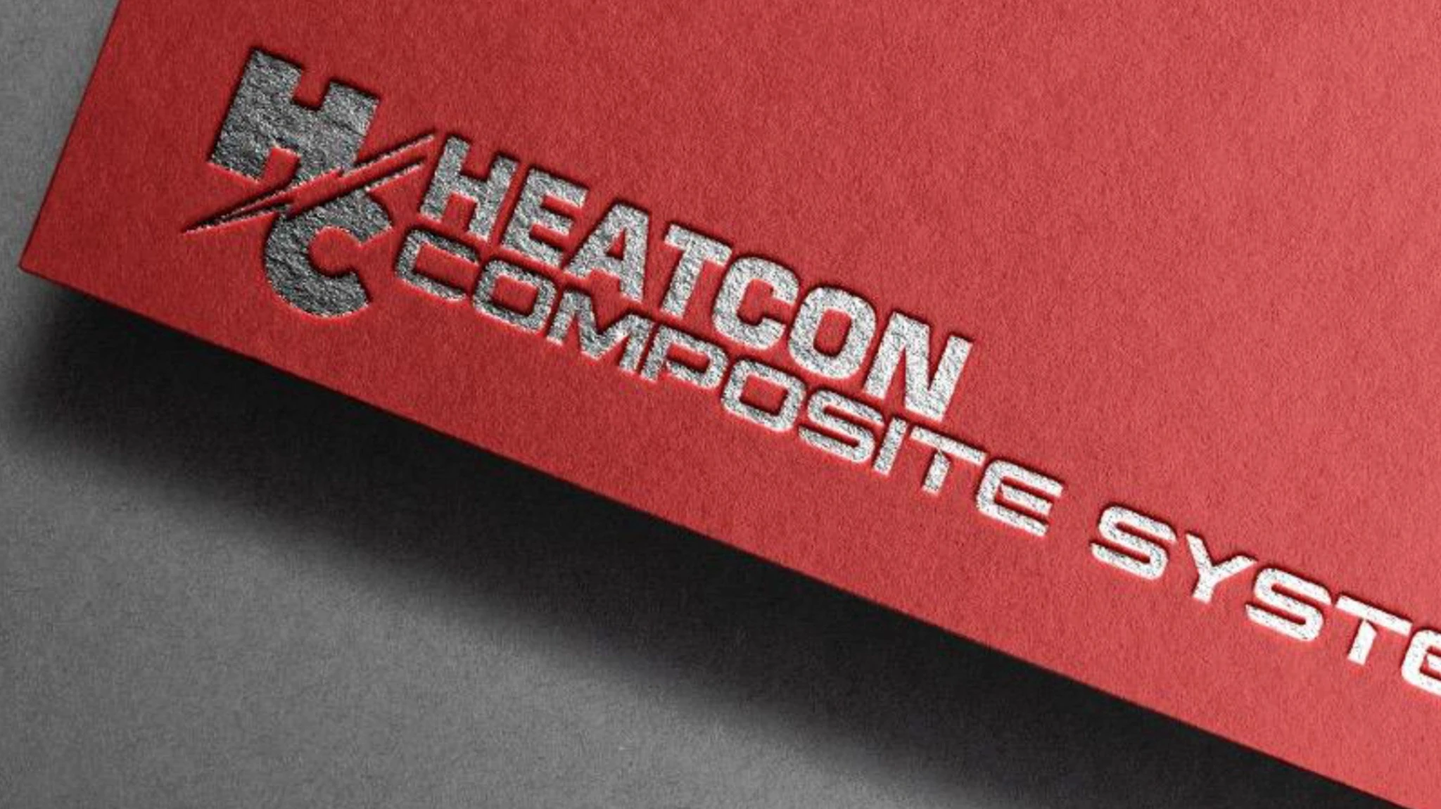 Silver Heatcon Composite Systems lettering and logo on a textured red brand application.