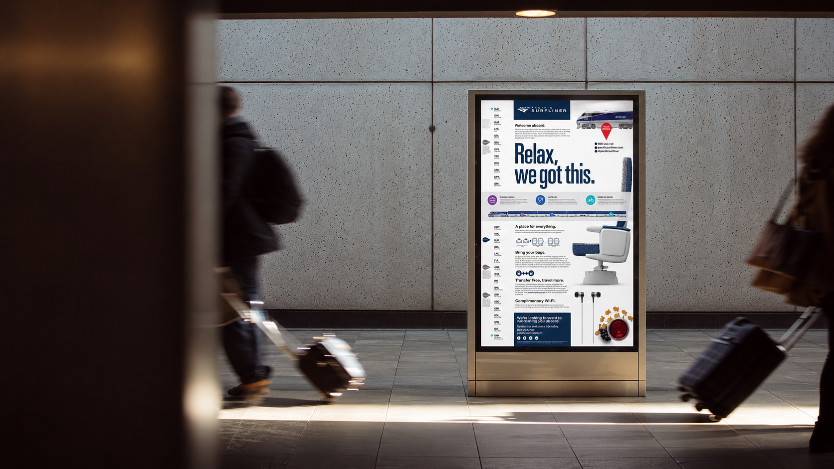 An Amtrak Pacific Surfliner Relax, we got this poster installed in a station display, with motion-blurred travelers and rolling suitcases passing nearby.