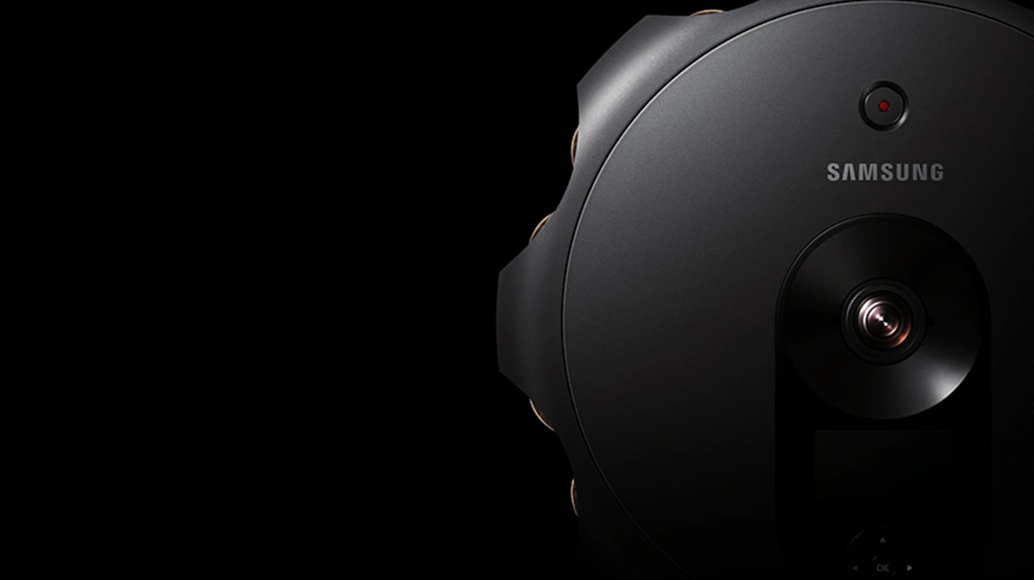 Close-up of a black Samsung 360 camera and its lens against a black background.